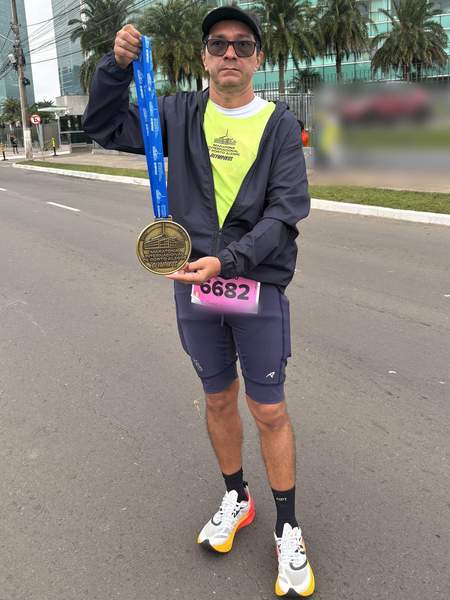 Mauricio Bezerra de Sousa erguendo a medalha da Maratona de Porto Alegre 2026
