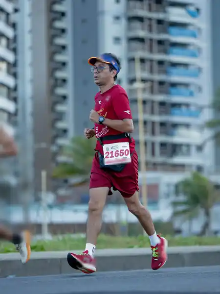 Mauricio Bezerra de Sousa correndo diante dos prédios da orla de Salvador na 20ª Meia Maratona Farol a Farol