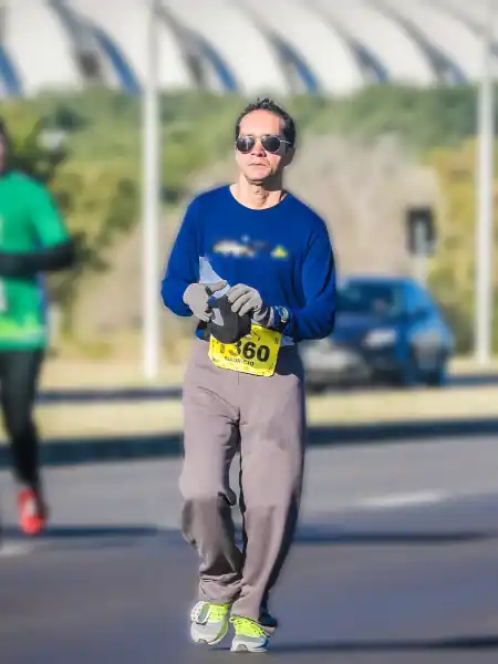 Mauricio Bezerra de Sousa segurando o gorro no percurso da Maratona de Porto Alegre 2016