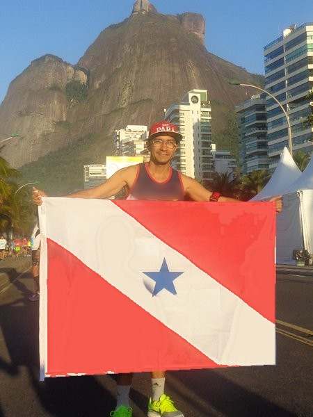 Mauricio Bezerra de Sousa de boné vermelho do Pará segurando a bandeira na orla do Rio de Janeiro