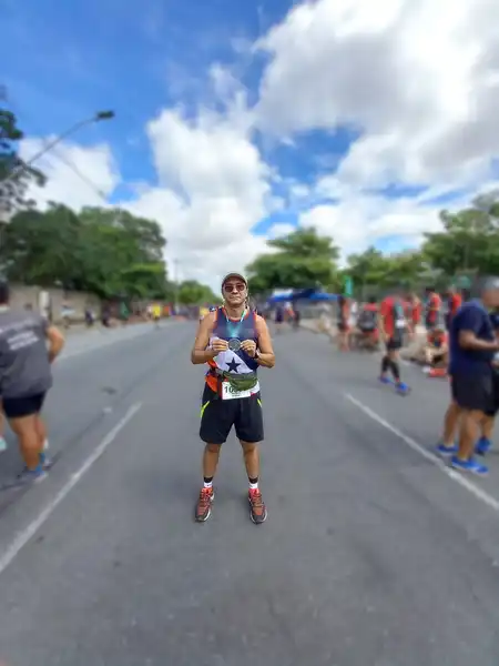 Mauricio Bezerra de Sousa segurando a medalha no meio da avenida depois da Corrida da Pampulha, Belo Horizonte, 2021