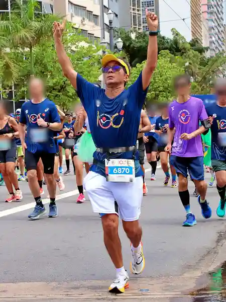 Mauricio Bezerra de Sousa com os braços erguidos correndo a 100ª Corrida Internacional de São Silvestre, em São Paulo