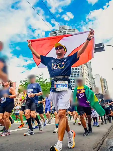 Mauricio Bezerra de Sousa com a bandeira do Pará erguida sob o céu azul de São Paulo na 100ª São Silvestre
